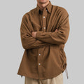 Person wearing a brown checkered shirt against a beige background